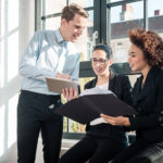 A group of employees work together, showing that they're team players through their collaboration