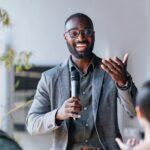 Man holding microphone giving a presentation to collogues