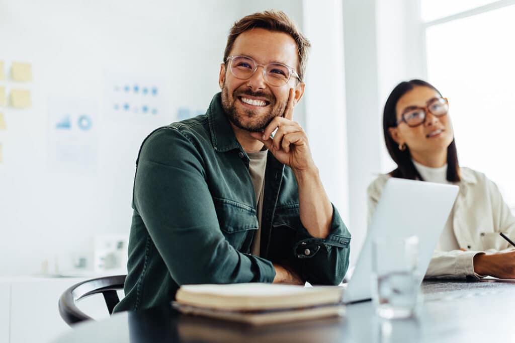 Happy business man sitting in a boardroom