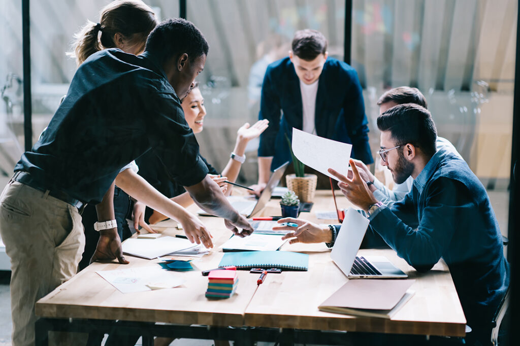 A group of young entrepreneurs shares ideas at a table