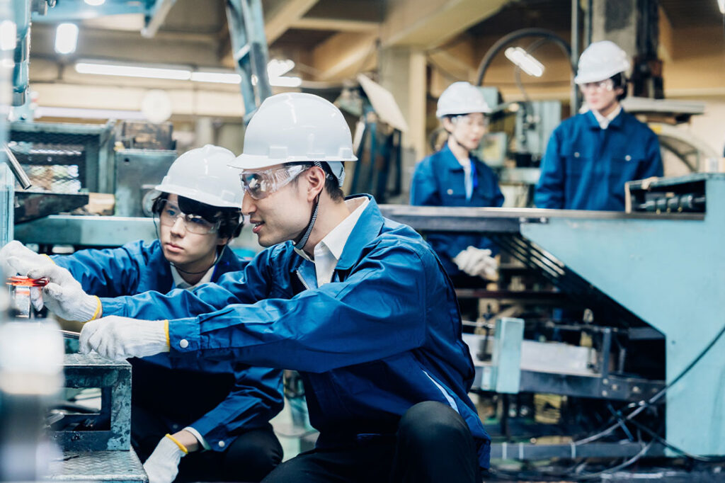 Workers servicing machinery at the factory