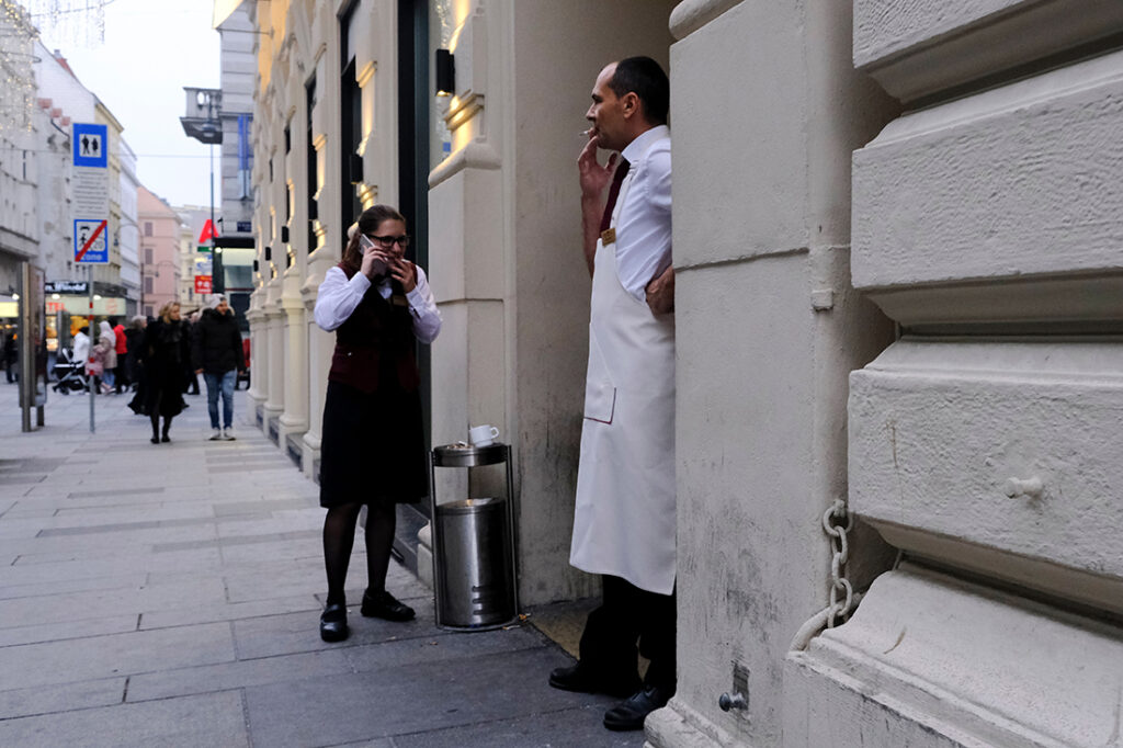 Hotel workers smoke cigarettes during their lunch break outside of a hotel in Vienna, Austria.