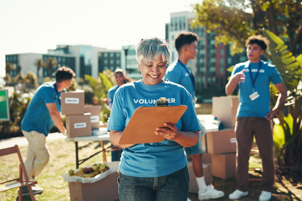 Happy, volunteers and mature woman with clipboard