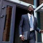 Professional leaving a building and smiling because he knew when to step down from a leadership role