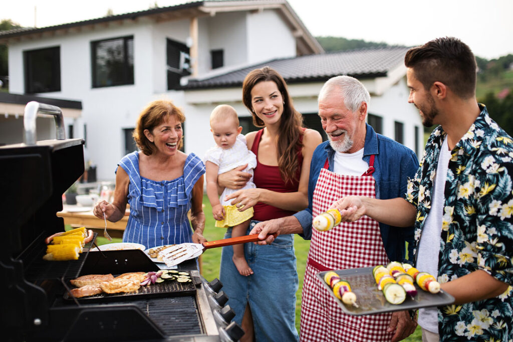 Portrait of multigeneration family outdoors on garden barbecue, grilling