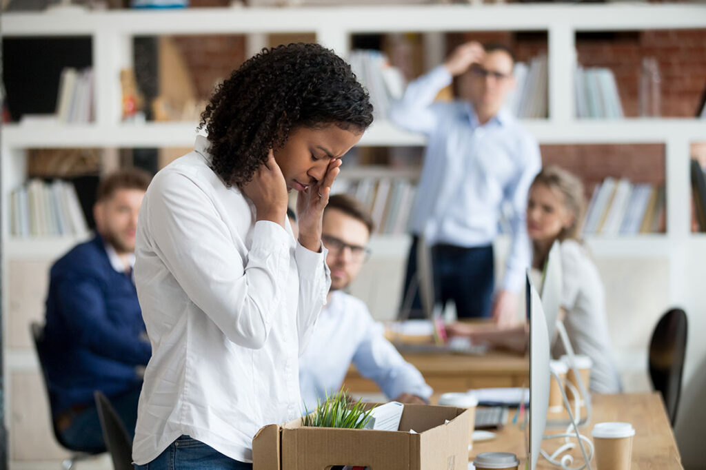 young employee packing belongings in box at workplace