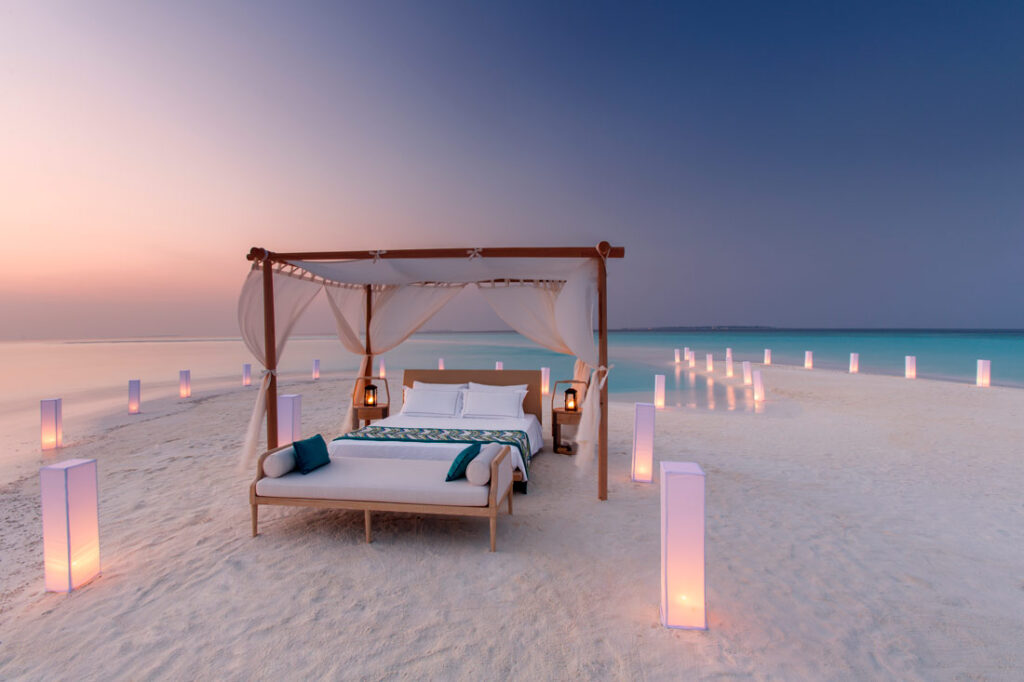 Bed set up by the concierge outside on the beach so guests can sleep under the stars at Milaidhoo Maldives