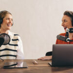 Two cheerful women recording a podcast