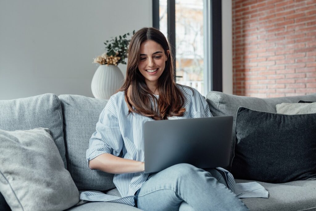 woman sitting on her couch using her computer