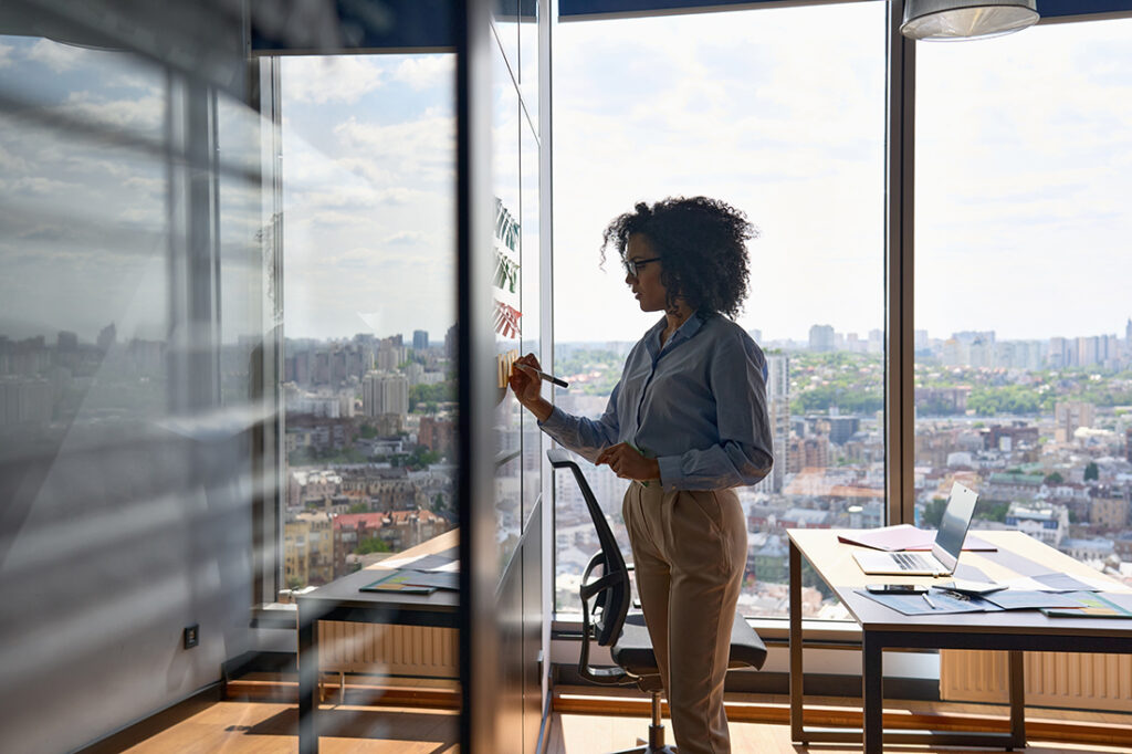 A woman plans out her plans for her second career on a whiteboard in an office building