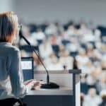 A female speaker in front of a crowd.