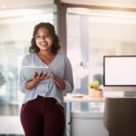 Smiling woman on her tablet before giving a presentation