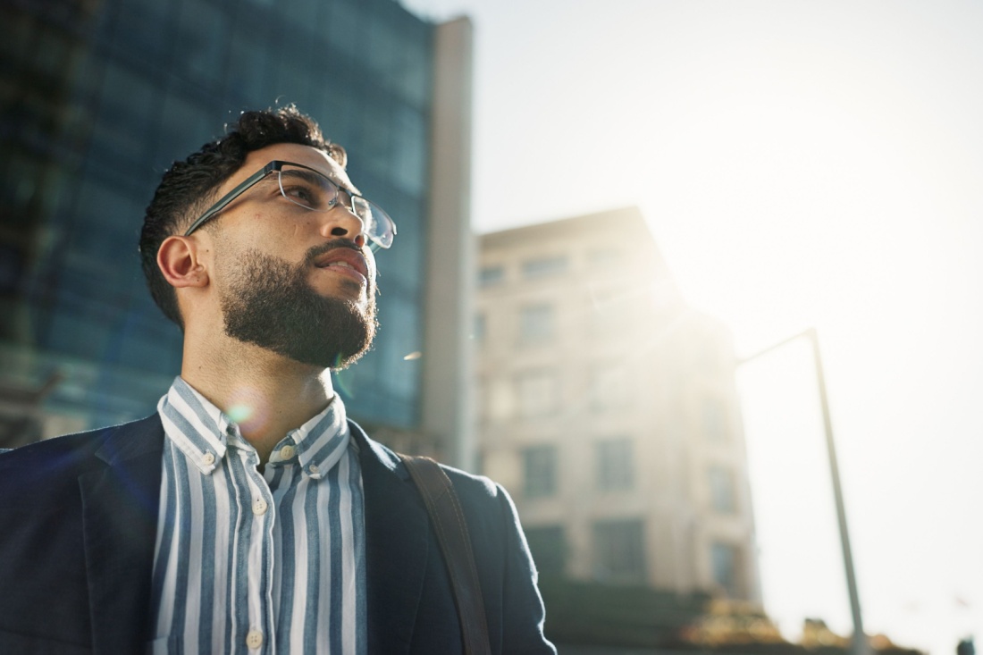 A professionally dressed man looking to the sun.