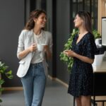 Two women greet each other in an office.