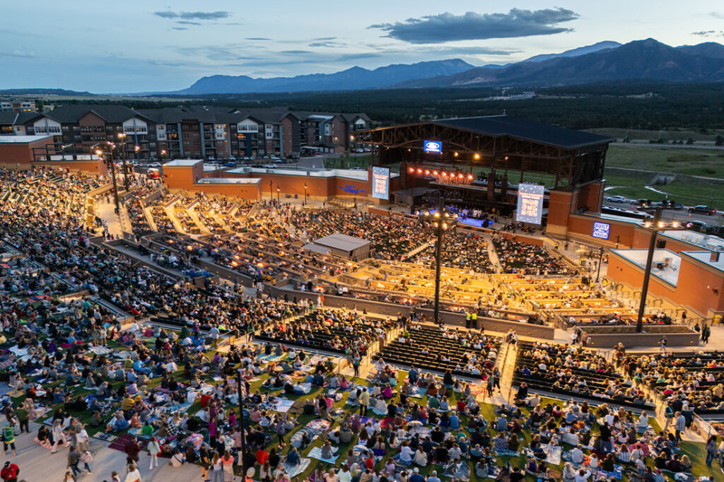 aerial of concert stadium at night and mountain backdrop