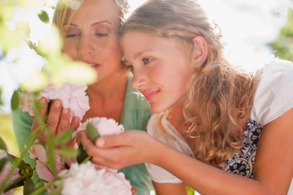 Mother and daughter admiring peony flowers