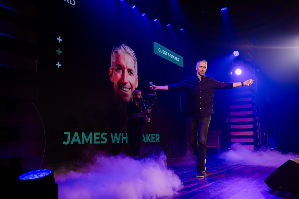 Speaker James Whittaker entering a stage.