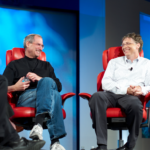 Steve Jobs and Bill Gates sitting in red chairs.
